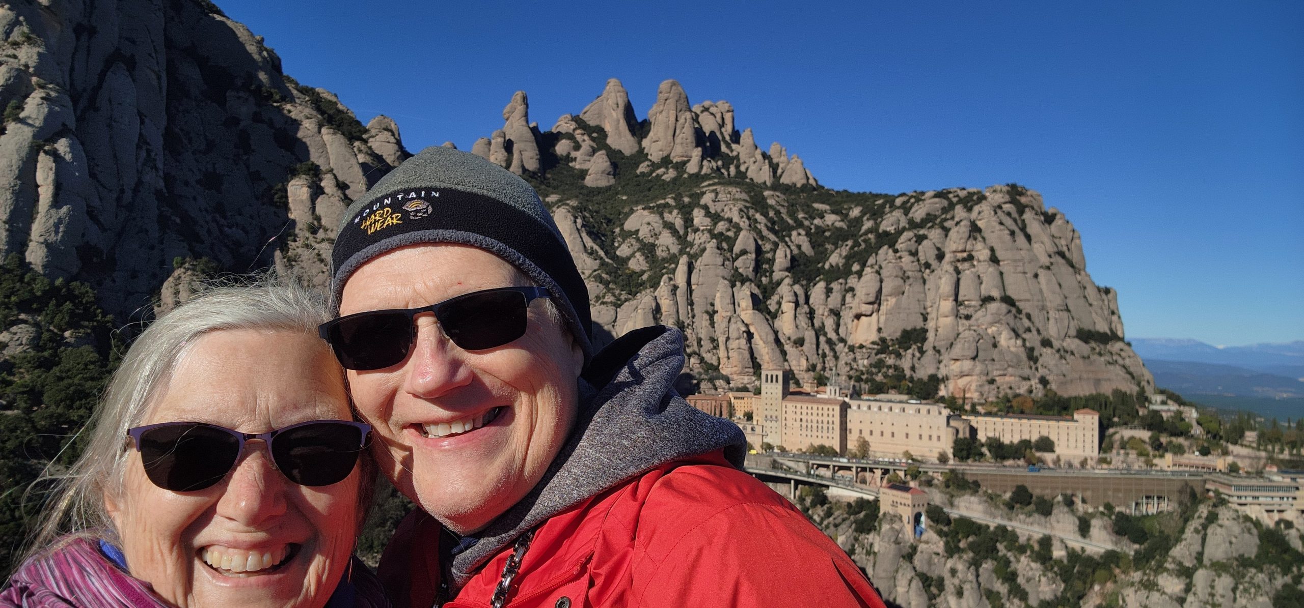 Kristin and Gregg with Montserrat Monastery and rock formations behind them.
